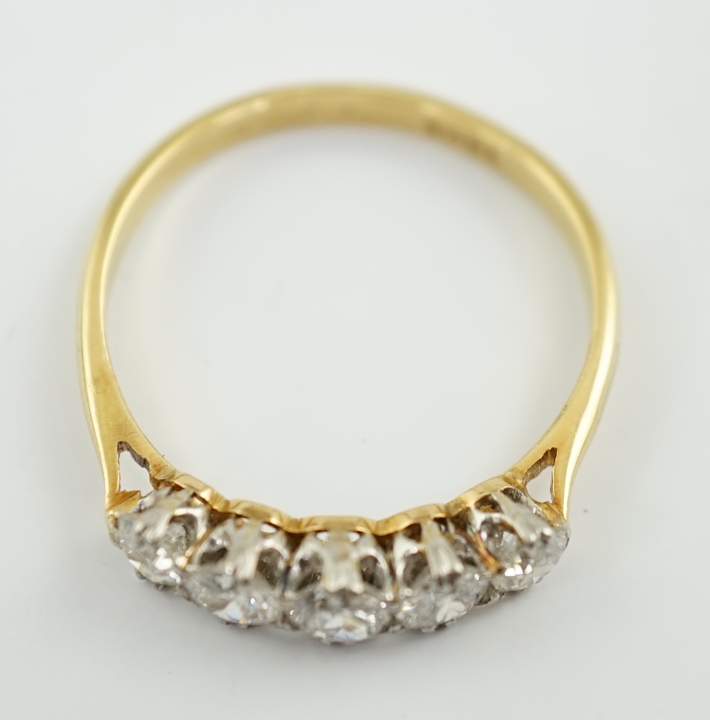 An 18ct gold and graduated five stone diamond set half hoop ring